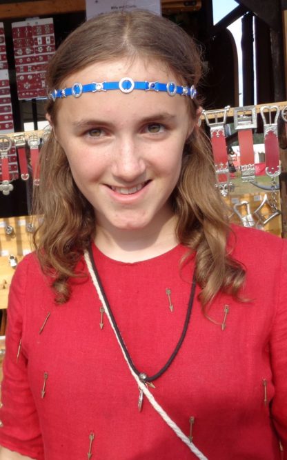 Young woman modeling a chaplet with a blue ribbon.