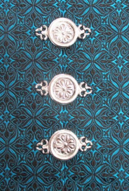 e examples of the interlocking clasp sewn an a blue and black brocade