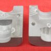Mold for the toy cooking pot tilted to show the markings on th ebottom of the bessel and the top of the lid