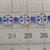 chaplet decoration with openwork star on ribbon, packed as tightly as possible, shown against a scale
