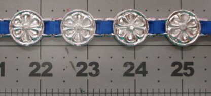 Flower chaplet decorations, packed as closely as possible, on a ribbon, shown against a scale