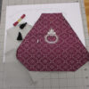 Contents of a kit to make a small purse in purple brocade.
