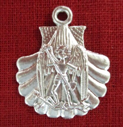 Angel driving a spear into the head of a devil beneath the angel's feet. This figure is mounted on a scallop shell pendant