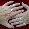two hands, next to one another, wearing all five adjustable rings plus a gold band