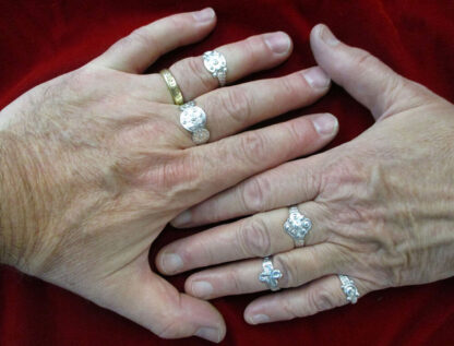 two hands, next to one another, wearing all five adjustable rings plus a gold band