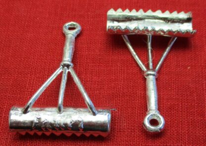 Front and back views of the curry comb pendant