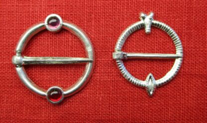 Two similar ring brooches, one with two stones, one with a penis and vulva