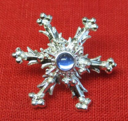Snowflake brooch with blue glass stone