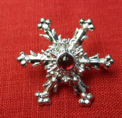 Snowflake brooch with garnet glass stone