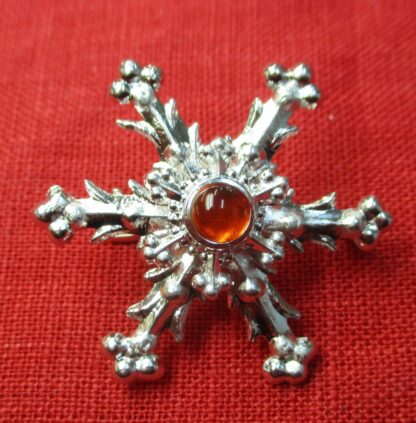 Snowflake brooch with orange glass stone