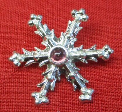 Snowflake brooch with purple glass stone
