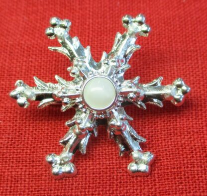 Snowflake brooch with white glass stone