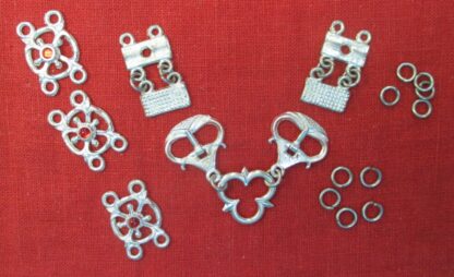Buckles linked to trefoil, chape and eyelet segments, three links wiht sotnes, and two sizes of jump rings, from the livery collar of links