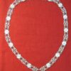 A long necklace of links, alternating a link with a garnet stones and roses.