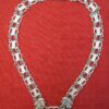 Short collar of links of esses with buckle fastening