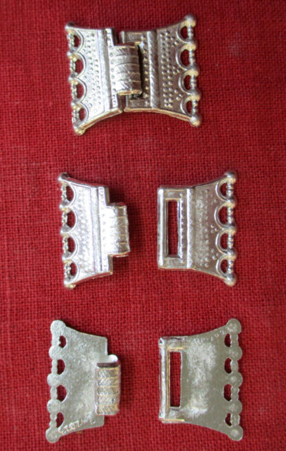 Flared clothing clasp shown hooked together, as separate pieces, and from the back