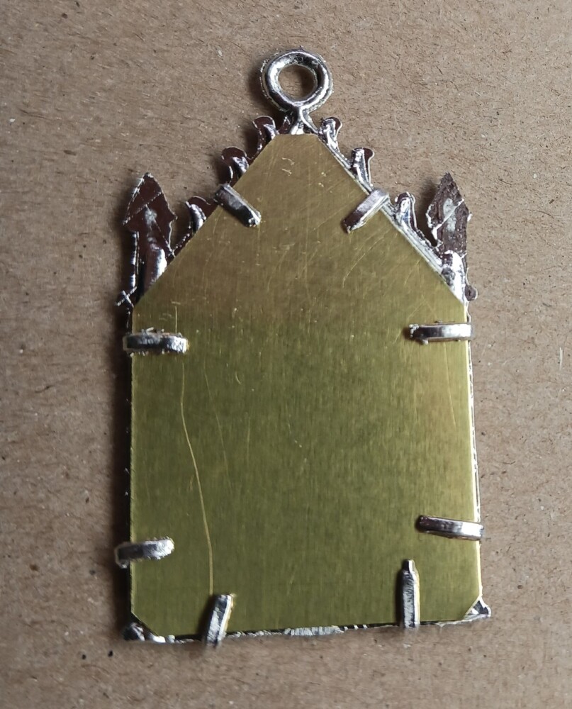 back of pendant with clips pressed down to hold backing.