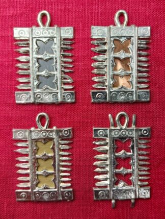 The comb pendant, shown with pewter, copper, and brass sheet backings, and with no backing.