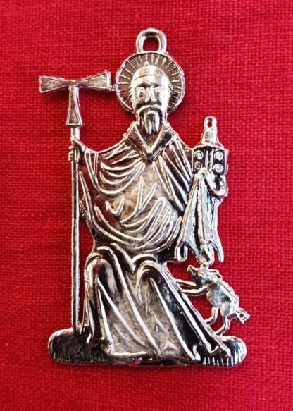 St. Anthony badge. The saint is seated. He holds a staff surmounted by a tau cross in his right hand. His left holds a book and a bell. A small pig jumps up towards him on his left side.